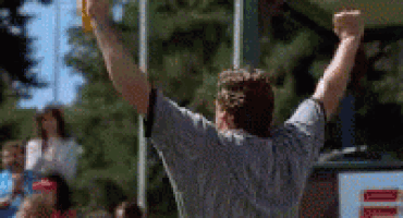 a man is raising his fist in the air while holding a frisbee .