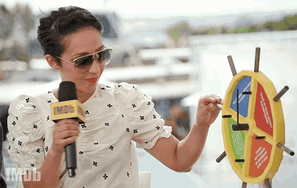 a woman playing a game with a microphone and a sign that says imdb