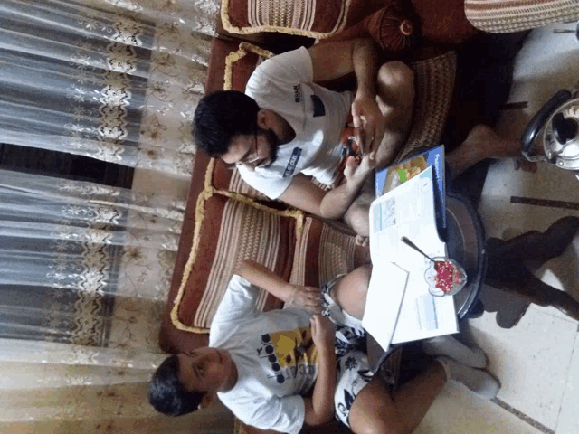 a man wearing a diadora shirt sits on a couch