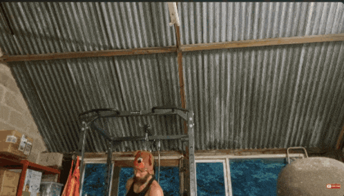 a man wearing a red hat is standing in front of a gym equipment