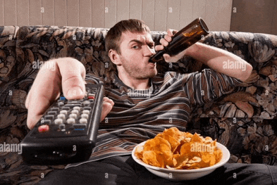 a man sits on a couch drinking beer and eating chips while holding a remote control