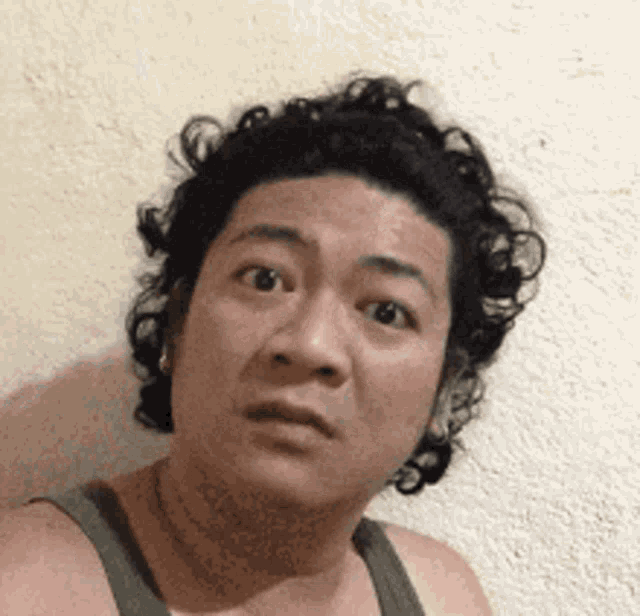a man with curly hair is making a funny face