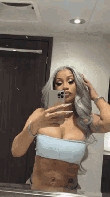 a woman is taking a picture of herself in the mirror