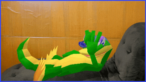 a green and yellow cartoon character is laying on a couch