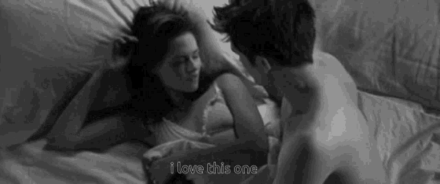 a black and white photo of a man and a woman laying on a bed with the words i love this one below them