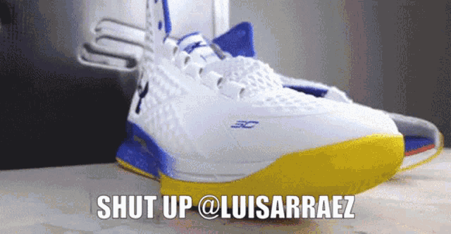 a pair of under armour shoes with a blue and yellow sole