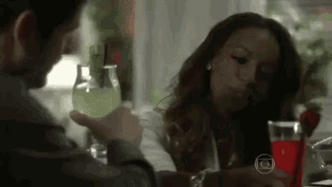 a man and a woman are sitting at a table drinking wine and talking .