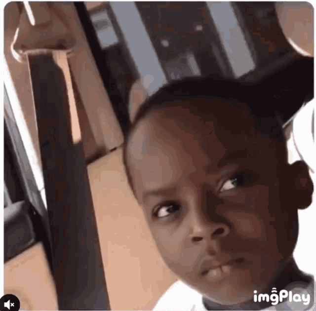 a young boy is making a funny face while sitting in a car with imgplay written on the bottom