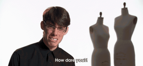 a man with glasses says how dare you in front of two mannequins