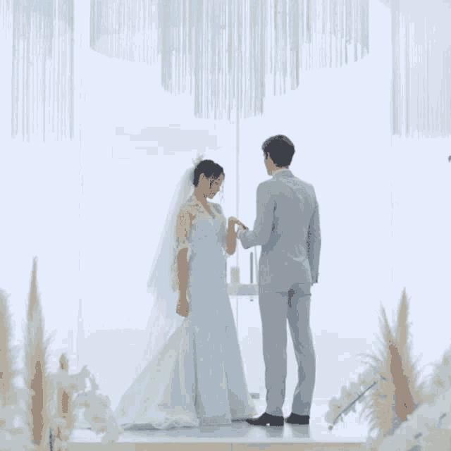 a bride and groom are standing in front of a window