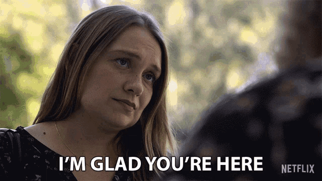 a woman says i 'm glad you 're here in front of a netflix logo
