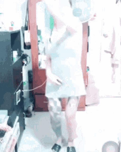 a woman in a white dress is dancing in a living room .