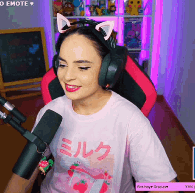 a woman wearing headphones and a pink shirt that says milk on it