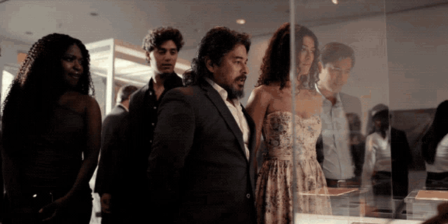 a group of people are looking at a display case