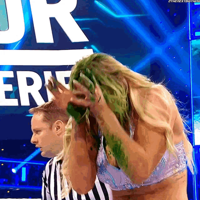 a woman with green hair is standing in front of a referee and a sign that says jr