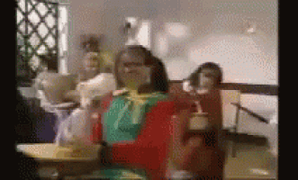 a group of people are sitting at a table in a restaurant eating food .