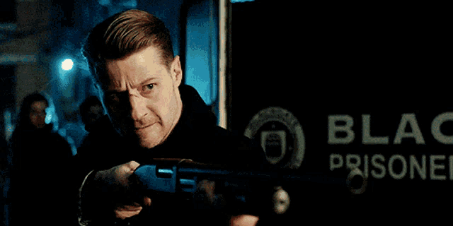 a man is holding a shotgun in front of a sign that says black prison .