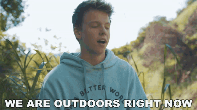 a young man wearing a hoodie that says better world