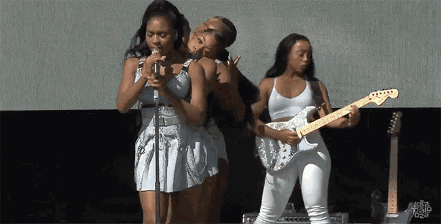 a group of women are singing and playing guitars on a stage with the words hello video on the bottom
