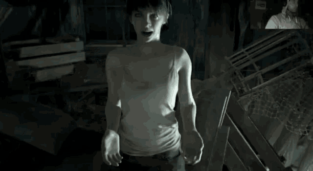 a woman in a white tank top stands in a room