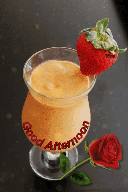 a glass of orange juice with a strawberry on top and the words good afternoon written on it