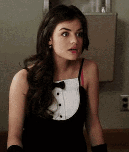 a woman wearing a tuxedo top and gloves