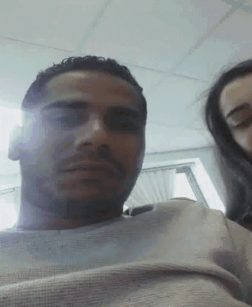 a man and a woman are looking at each other in a room .