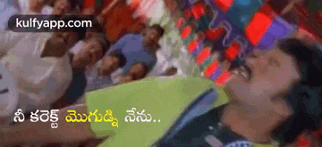 a man is laying on a bed with a group of people behind him in a movie scene .