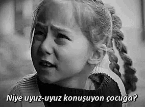a little girl is crying in a black and white photo with a caption in a language other than english .