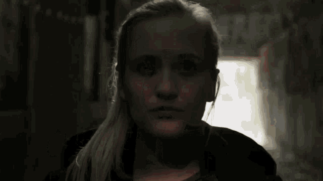 a close up of a woman 's face with a dark background