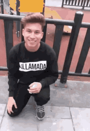 a young man wearing a sweater that says llamada