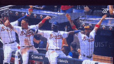 a group of braves baseball players celebrate a win