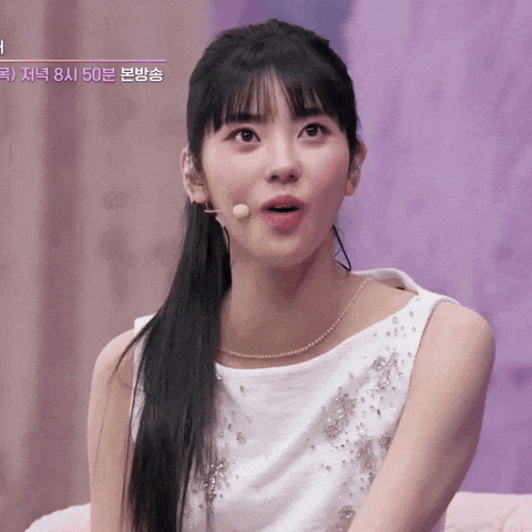 a woman wearing a white dress and a microphone with korean writing on the bottom