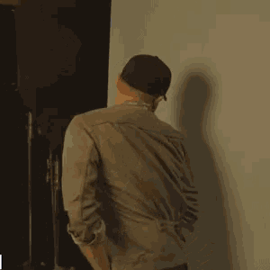 a man in a baseball cap stands in front of a light