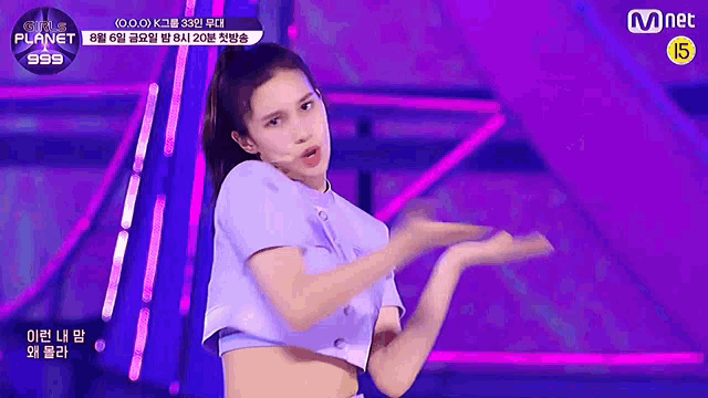 a girl is dancing on a stage with a mnet logo in the background