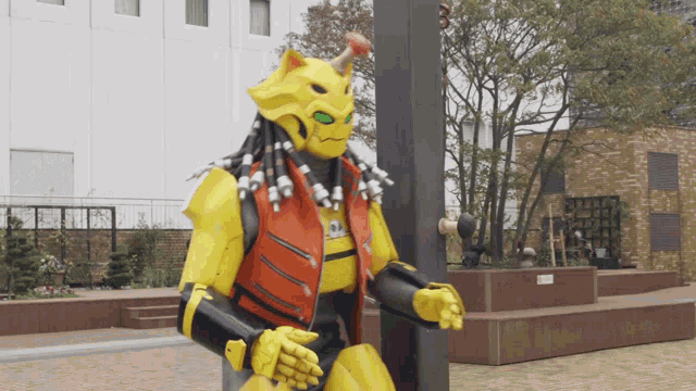 a yellow robot with dreadlocks and horns stands in front of a building
