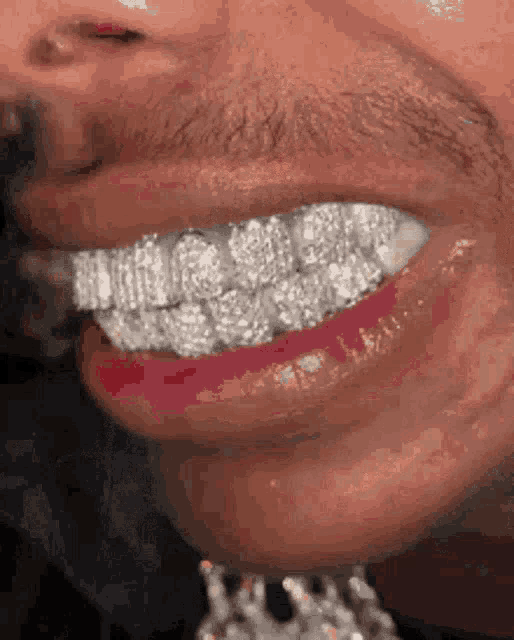a close up of a man 's mouth with diamonds on his teeth