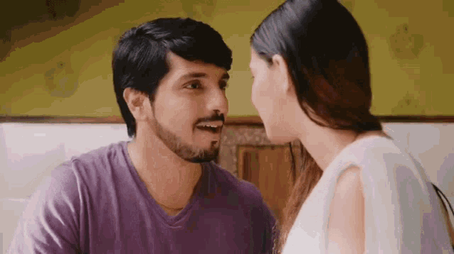 a man and a woman are looking at each other with their eyes closed .
