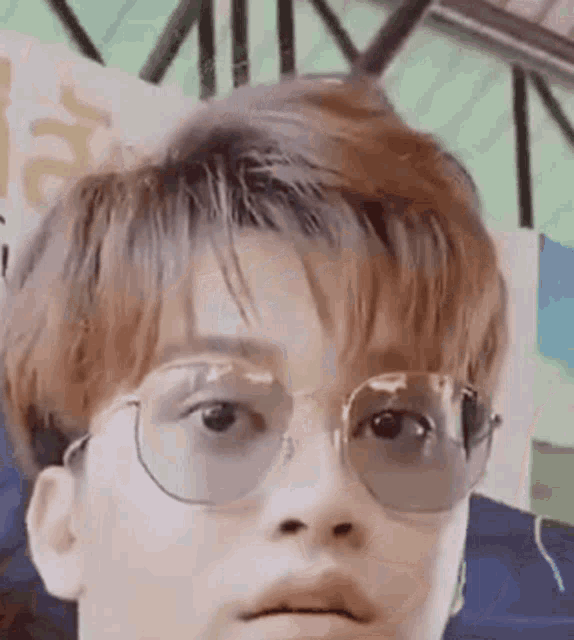 a close up of a young man wearing glasses .