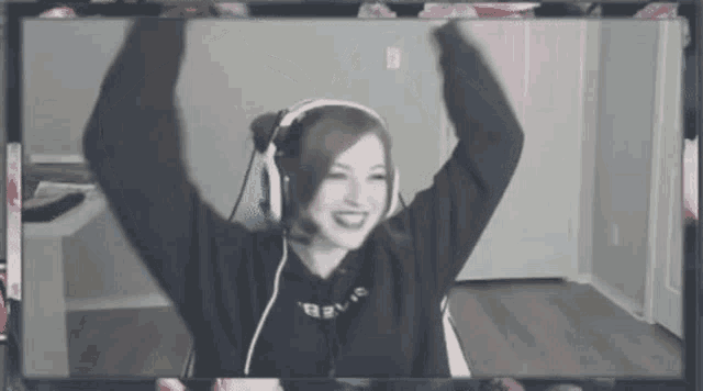 a woman wearing headphones and a microphone is sitting in front of a computer screen .