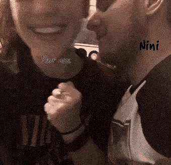 a man is kissing a woman on the cheek and the words " nini " are written on the man 's neck