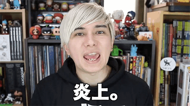 a man wearing a black hoodie has chinese writing on his shirt
