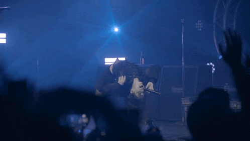 a person laying on their back on a stage with a mesa amplifier in the background