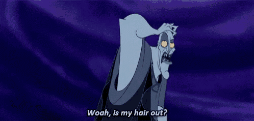 a cartoon character from hercules is standing in front of a purple curtain and talking .