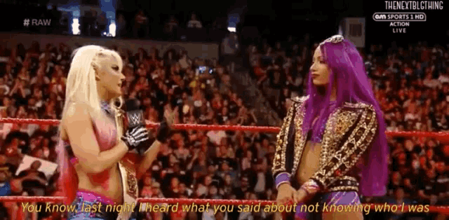 a woman with purple hair is talking to another woman with blonde hair