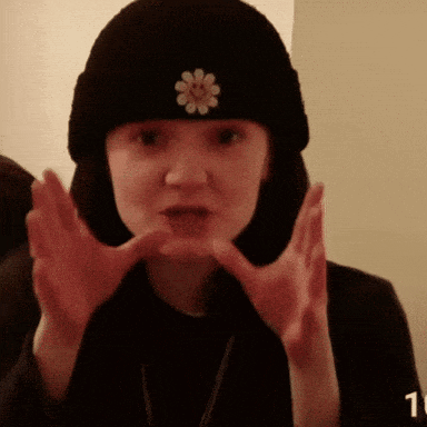 a woman wearing a black beanie with a flower on it