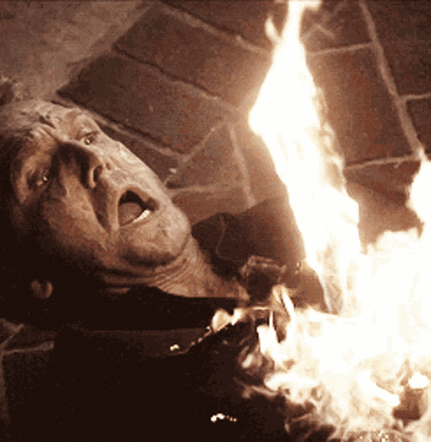 a man is laying on the ground with his mouth open and a fire coming out of his mouth