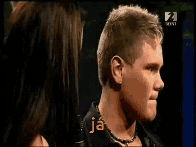 a man singing into a microphone with the word ja on the screen