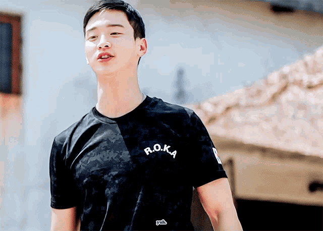 a man wearing a black t-shirt that says r.o.k.a.