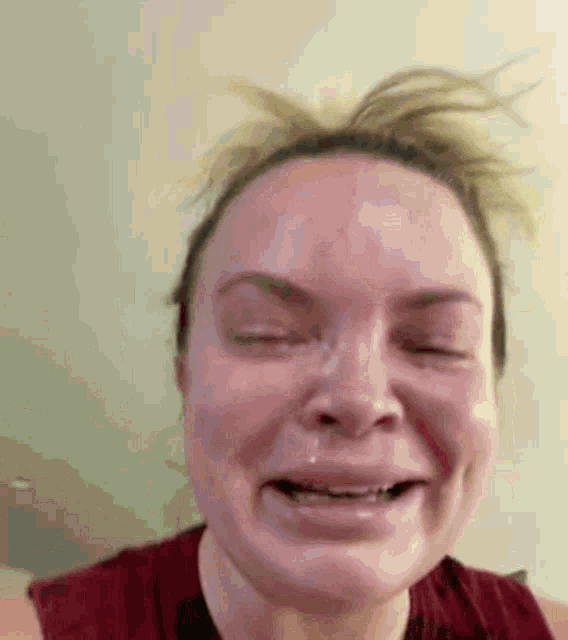 a close up of a woman 's face with her eyes closed and a tear running down her face